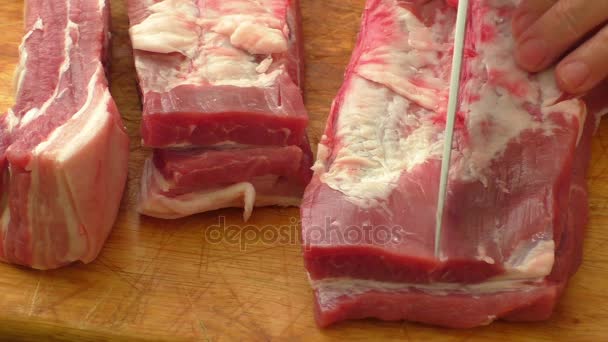 Fleisch an Bord und Hände. Messer schneiden rohes Schweinefleisch - Filmmaterial, Video