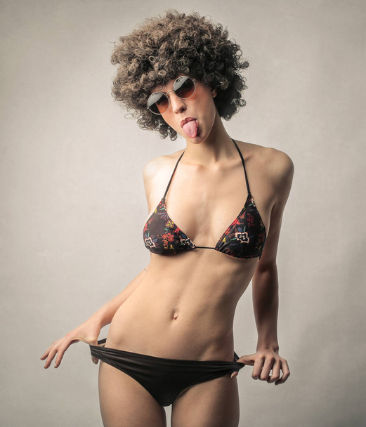 Woman in bikini sticking her tongue out - 写真・画像