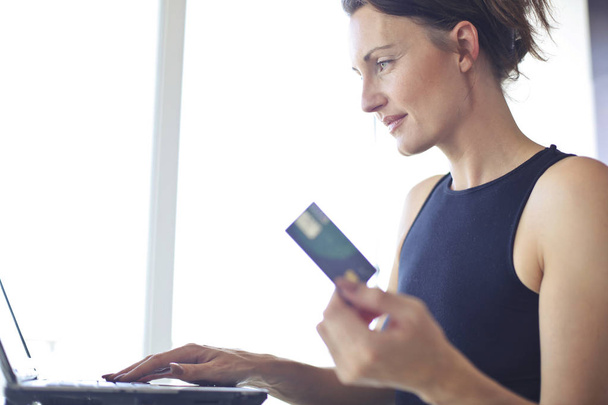 Brunette woman shopping with credit card - Fotó, kép