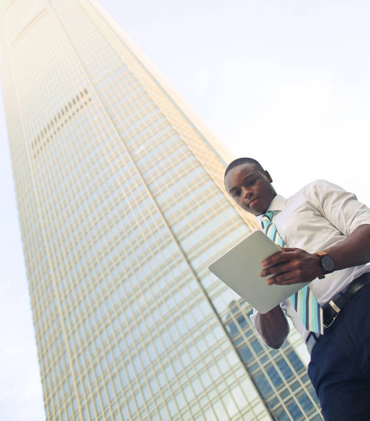 Young black businessman in front of skyscraper - Zdjęcie, obraz