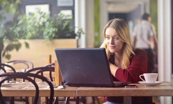 Blond woman with laptop in cafe - Foto, imagen