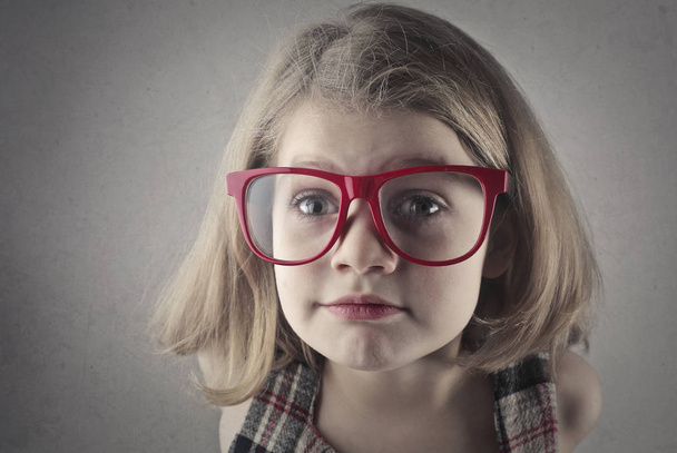 Маленька дівчинка в величезних червоних окулярах
 - Фото, зображення