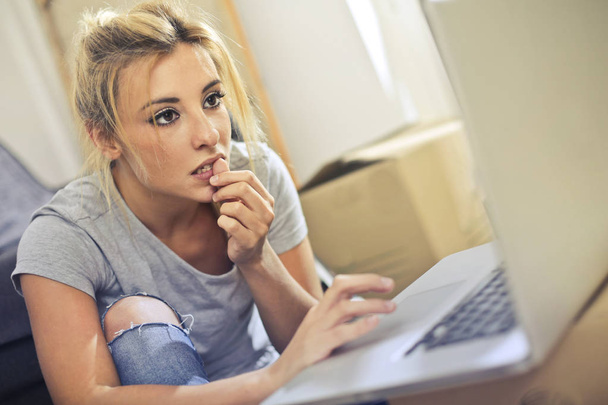 Stressed blond woman in front of laptop - Foto, afbeelding