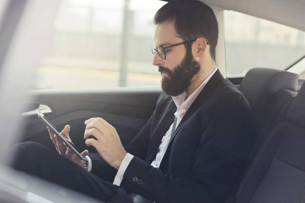 Businessman with phone in the car - Foto, imagen