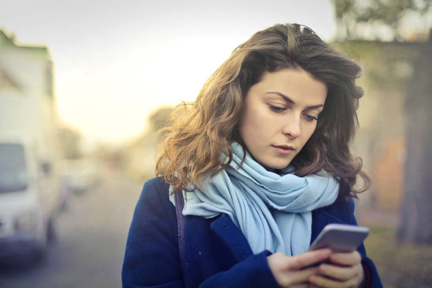 Brunette woman looking at phone - Photo, image