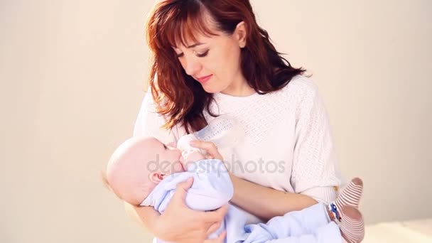 mamá está alimentando al bebé con leche de un biberón
 - Imágenes, Vídeo