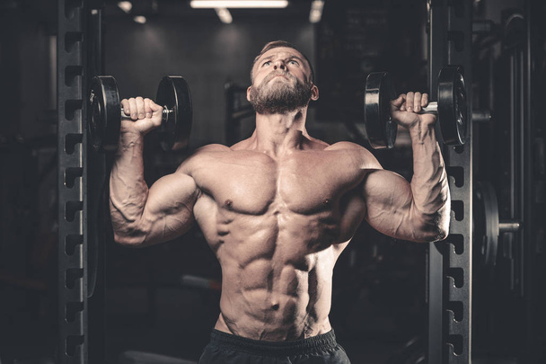 Caucasian sexy fitness male model execute exercise with dumbbell - Foto, Imagem