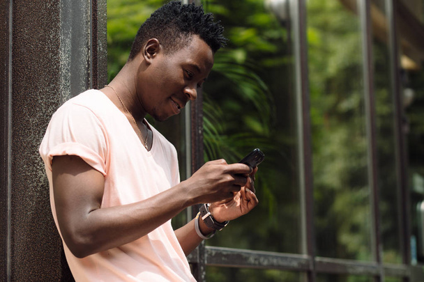 African american man using cellphone in summer city - Valokuva, kuva