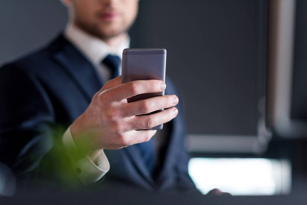 Stylish man is sitting in office with smartphone - Foto, immagini