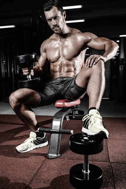 Caucasian sexy fitness male model execute exercise with dumbbell - Fotografie, Obrázek