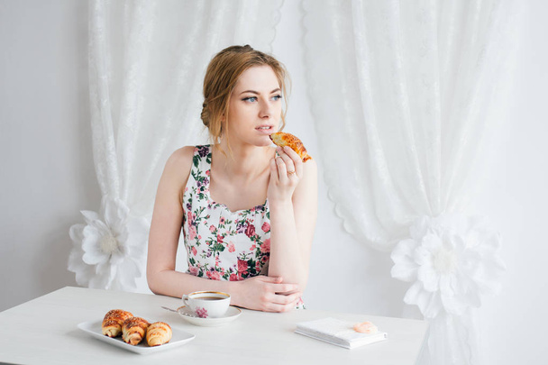 Woman having Breakfast with tea and fresh croissants homemade - Фото, изображение