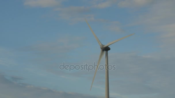 Regelmatige windturbines draaien in de wind op een blauwe hemel. - Video