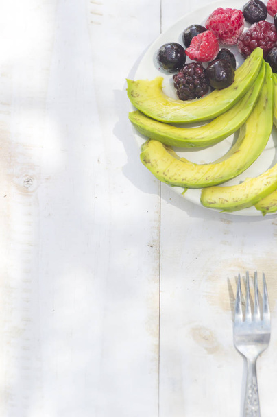 Healthy breakfast ingredients avocado slices with mix berries an - Photo, Image