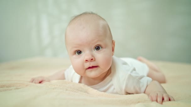 Baby liggend op buik op een zachte linnen glimlachen - Video
