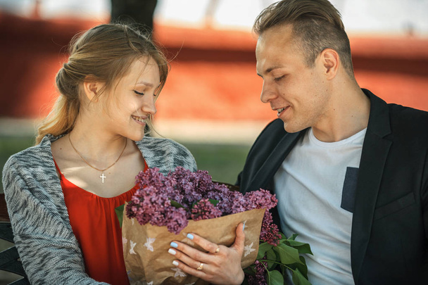 Couple in love on the bench with purple flowers. - Foto, Bild