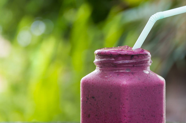 Delicious berry smoothies on wood in the garden. - Photo, Image