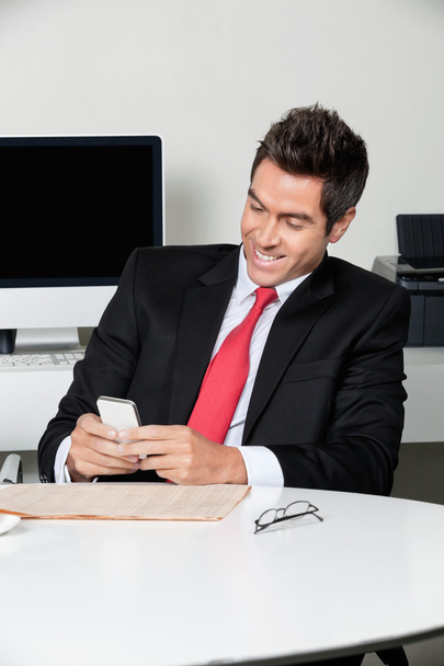 Businessman Using Cell Phone At Desk - Photo, Image