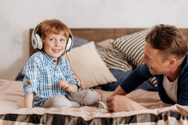 Positive delighted man child listening to music - Photo, Image