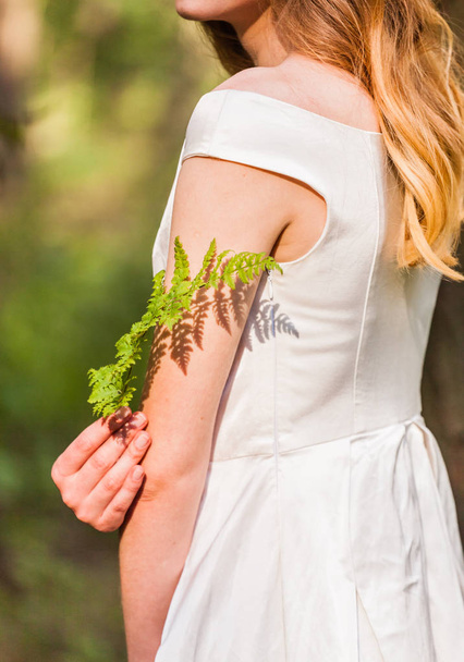 Young woman with fern - Фото, изображение