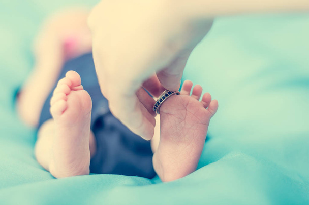 Nahaufnahme neugeborener Füße mit Ehering. - Foto, Bild