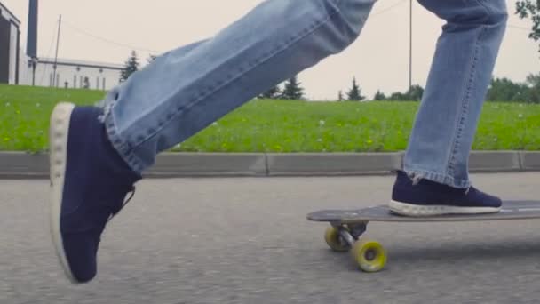 Jalkojen nuori mies ratsastaa longboard
 - Materiaali, video