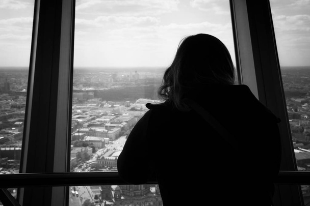 Silhouette de vue arrière de la femme regardant par une fenêtre à la
  - Photo, image