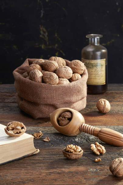 Old nutcracker and walnuts on table - Φωτογραφία, εικόνα