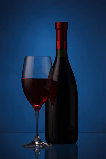 Weinglas und Flasche mit Rotwein - Foto, Bild