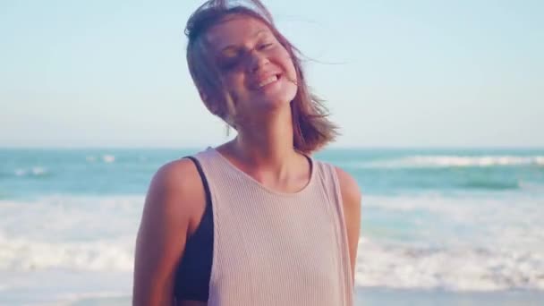 Chica alegre feliz en la playa de arena negra soplando beso. Mujer feliz sonriendo al aire libre en la naturaleza, riendo con placer
. - Imágenes, Vídeo