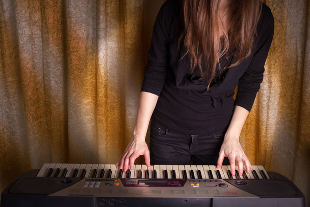 unrecognizible girl musician playing on electronic piano - Foto, Imagen