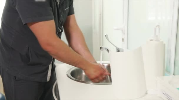 A felnőtt orvos gondosan mossa a kezét, mielőtt a latex kesztyű - Felvétel, videó