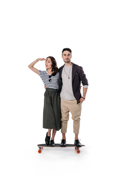 молодая пара, стоящая на скейтборде
 - Фото, изображение