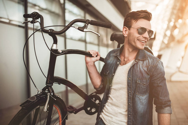 Stylish man with bicycle - Фото, изображение