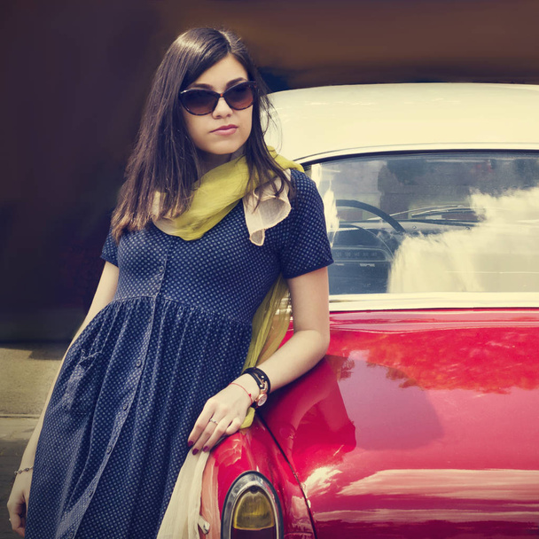 Gyönyörű fiatal hölgy közelében, egy retro autó. - Fotó, kép