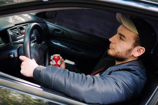 Człowiek pije piwo podczas jazdy samochodem - Zdjęcie, obraz