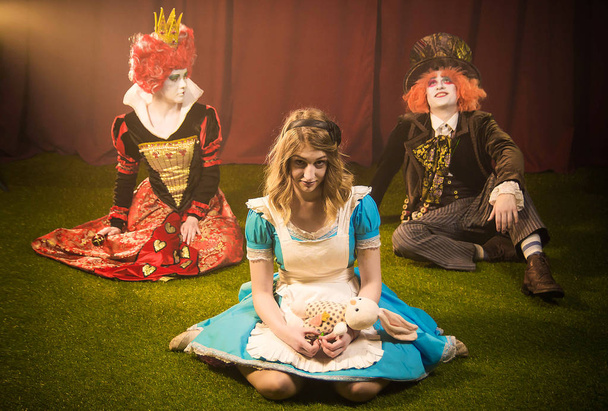 Dreamy hatter and serious Alice with the queen - Photo, Image
