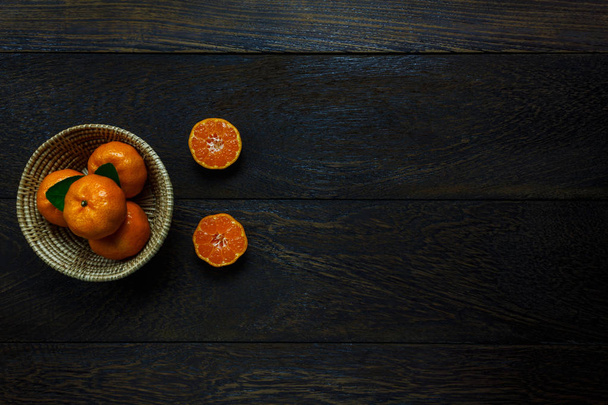 Top view sliced orange on rustic wooden and basket with copy. - Foto, imagen
