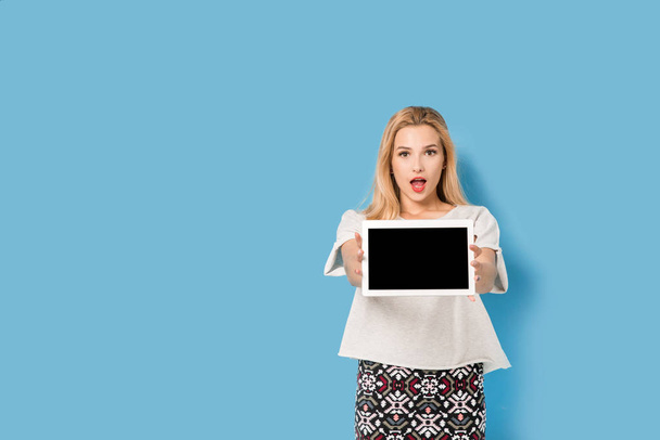 Young blonde hold her tablet pc and is surprised - 写真・画像