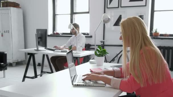 Egy szőke nő üzleti partner ő 20-as ül előtt a számítógép 20s 4 k tiszta üveg asztalára portréja - Felvétel, videó