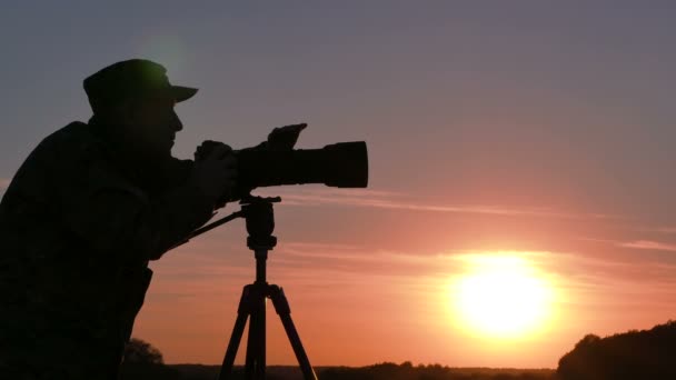  4K.Landscape άνθρωπος φωτογράφος λειτουργεί με κάμερα στο ηλιοβασίλεμα  - Πλάνα, βίντεο