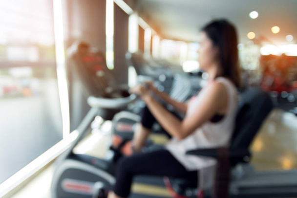 blurred woman cycling burn fat on bicycle cardio machine - Photo, Image