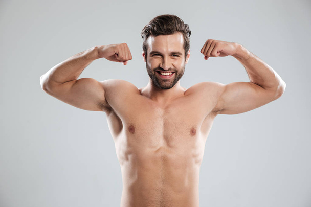 Man showing his biceps and looking at camera - Foto, immagini