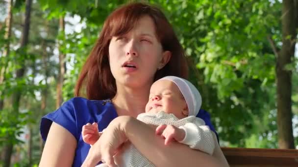 mother holds small child in hands of, small child wakes up and cries, walking in summer Park - Footage, Video