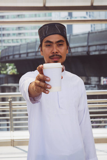muslim man drink coffee in city - Foto, Imagen