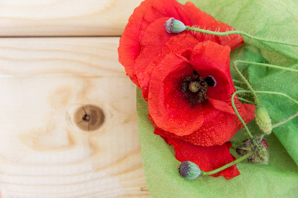 Blossoming wild poppies on a light wooden background.  - Photo, Image
