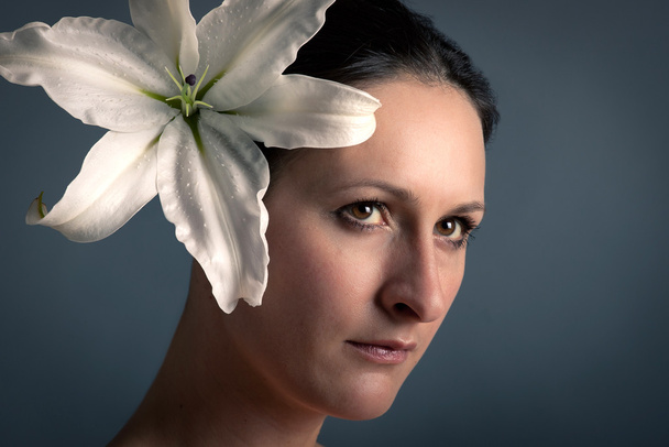 Close up portrait of beautiful girl with Lilium white flower - Fotó, kép