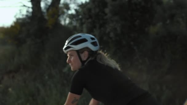 Női úton kerékpáros a naplementében - Felvétel, videó