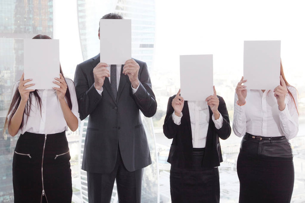 Business group holding white papers - 写真・画像