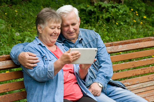 Pari eläkeläistä käyttää tablettia löytääkseen tietoa
 - Valokuva, kuva