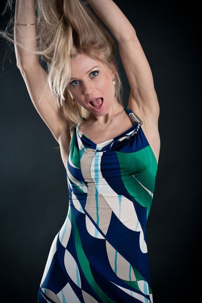 Attractive blond woman jumping against black background - Foto, immagini